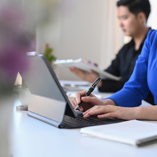 Cropped shot smiling business woman sitting in meeting room and using computer tablet.